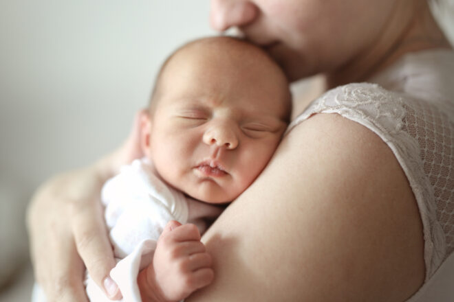 Zdjęcie noworodka wtulonego w mamę.
