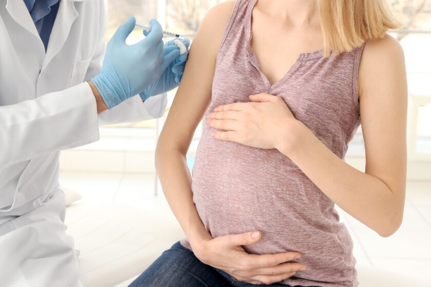 Zdjęcie lekarza, który podaje szczepionkę kobiecie w ciąży