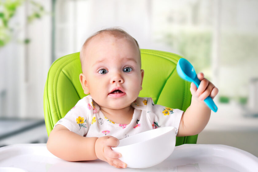 Zdjęcie dziecka, które je posiłek w krzesełku do karmienia