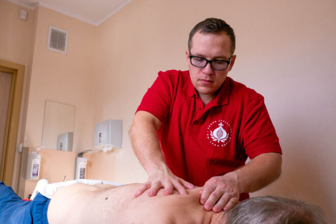 Zdjęcie masażysty, który masuje mężczyznę.