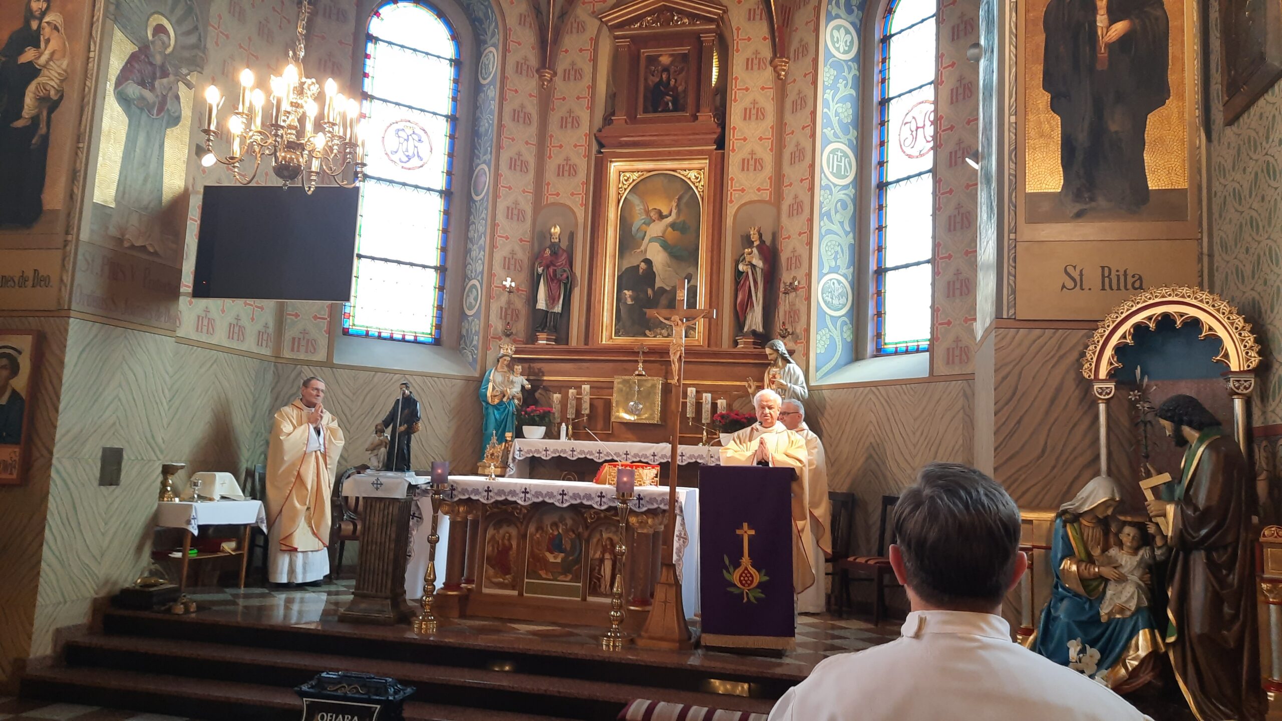 Zdjęcie księży, którzy odprawiają mszę świętą w kościele.