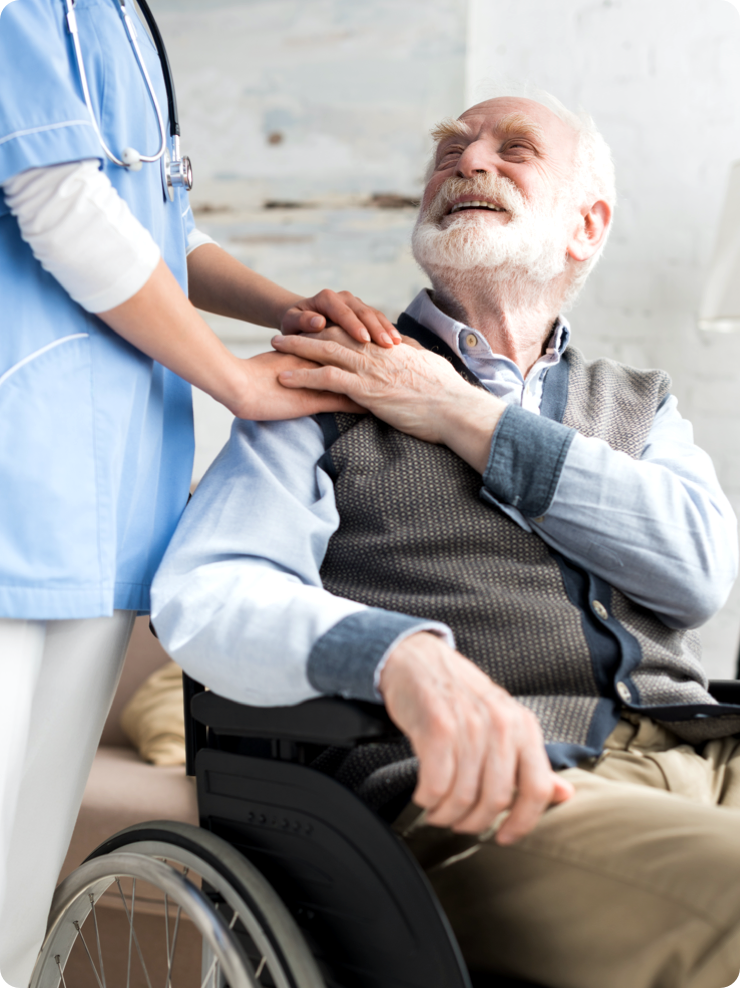 Zdjęcie starszego mężczyzny na wózku inwalidzkim. Za nim stoi lekarka i trzyma na jego ramieniu rękę.