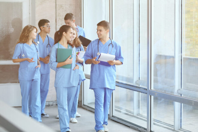 Zdjęcie lekarzy, którzy idą przez szpitalny korytarz.