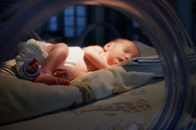 Zdjęcie noworodka w inkubatorze.