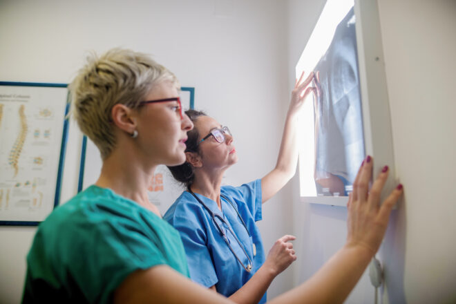 Zdjęcie dwóch lekarek, które oglądają zdjęcie rentgenowskie.