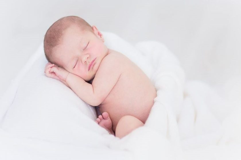 Zdjęcie przedstawia śpiącego noworodka.
