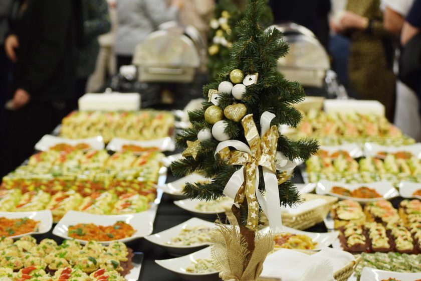 Fotografia przedstawia stół ze świątecznymi potrawami i niedużą choinką