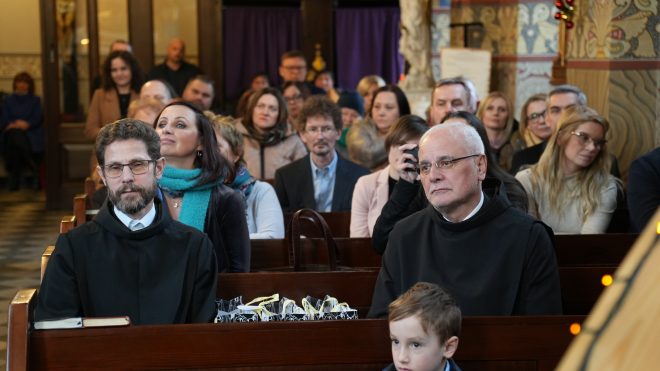 Zdjęcie przedstawia grupę osób uczestniczącą we mszy świętej