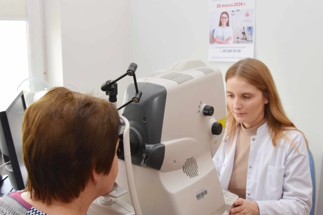 Zdjęcie przedstawia lekarza okulistę, który przeprowadza badanie z pacjentem