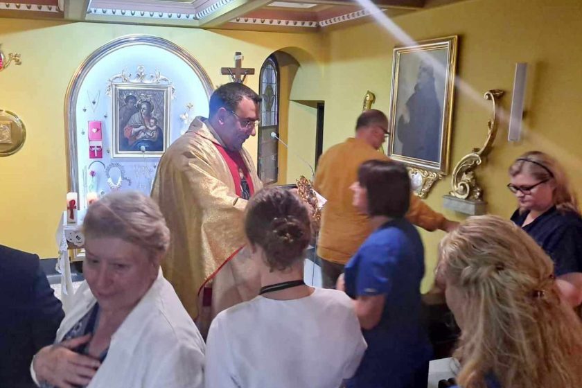 Zdjęcie przedstawia osoby uczestniczące we mszy świętej
