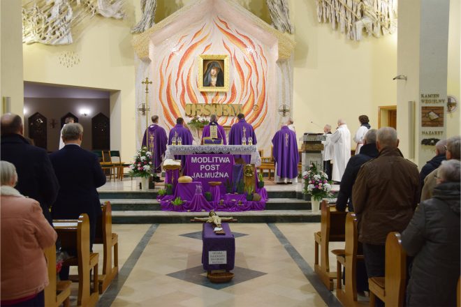 Liturgia przy głównym ołtarzu kościoła. Duchowni w fioletowych szatach liturgicznych stoją przed ołtarzem, który zdobi napis „Modlitwa, Post, Jałmużna”, symbolizujący wielkopostne praktyki religijne