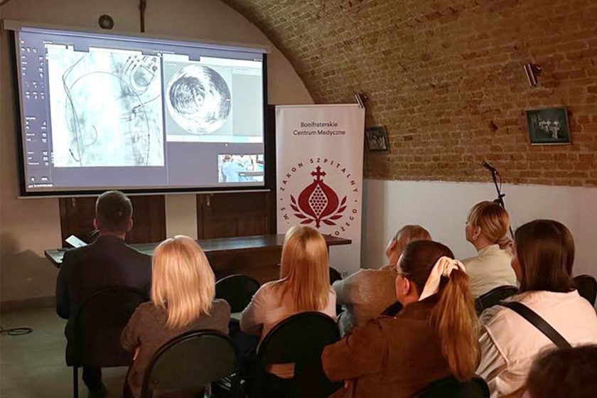 Uczestnicy spotkania oglądają projekcję obrazów diagnostycznych podczas prezentacji w sali wykładowej Bonifraterskiego Centrum Medycznego.