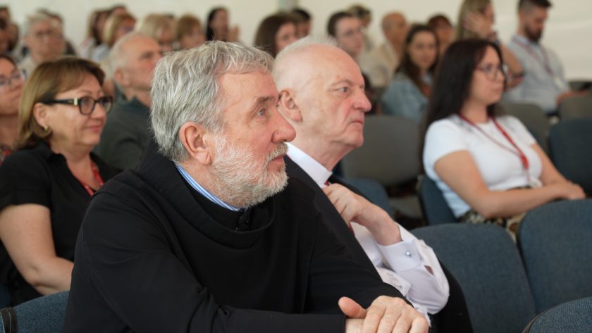 Wśród słuchaczy konferencji zauważalni są zakonnicy w tradycyjnych habitach i świeccy uczestnicy, skupieni na przebiegu prezentacji.
