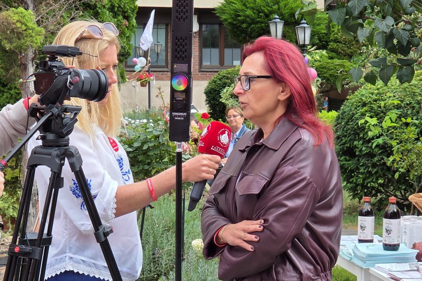 Wywiad przed kamerą – Kobieta w bordowej kurtce udziela wywiadu dla Bonifraterskiego Centrum Medycznego, trzymająca mikrofon dziennikarka nagrywa rozmowę