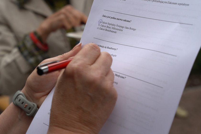 Quiz o Bonifratrach – Zbliżenie na dłoń osoby wypełniającej quiz o Zakonie Bonifratrów; widoczne pytanie z zaznaczoną odpowiedzią