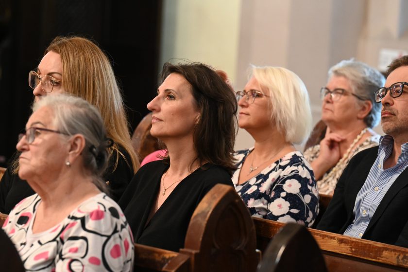 Kobiety i mężczyźni uczestniczący w nabożeństwie jubileuszowym Bonifratrów, ujęcie skupione na twarzach wiernych w ławkach