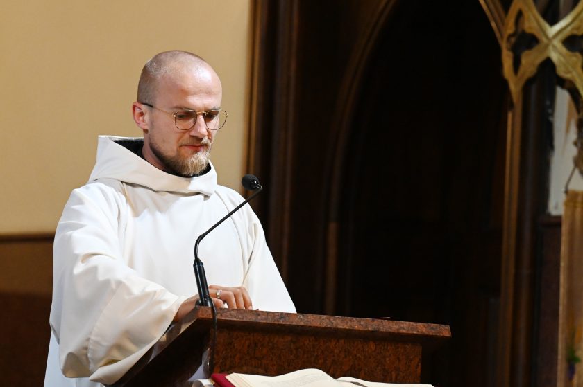 Zakonnik w białym habicie głosi Słowo Boże przy ambonie, podczas nabożeństwa w kościele Bonifratrów