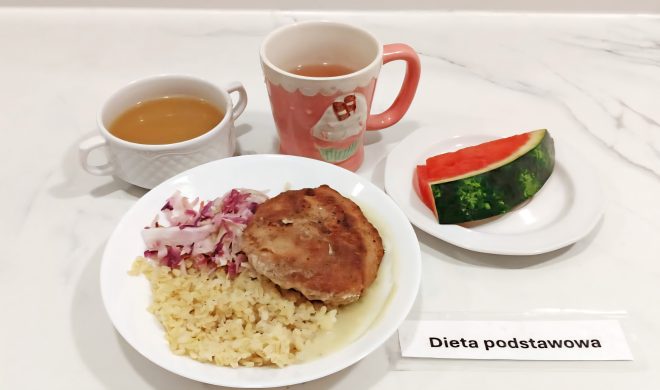 Porcja ryżu z sosem i kotletem, podana z surówką z białej i czerwonej kapusty. Do zestawu filiżanka rosołu, kubek herbaty oraz kawałek świeżego arbuza na deser. Posiłek w ramach diety podstawowej