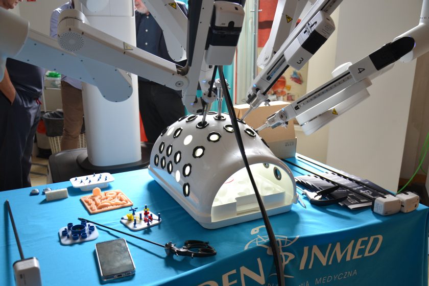 Robot chirurgiczny podczas ćwiczeń na trenażerze – ramiona robota wykonują precyzyjne ruchy w specjalnej kopule treningowej