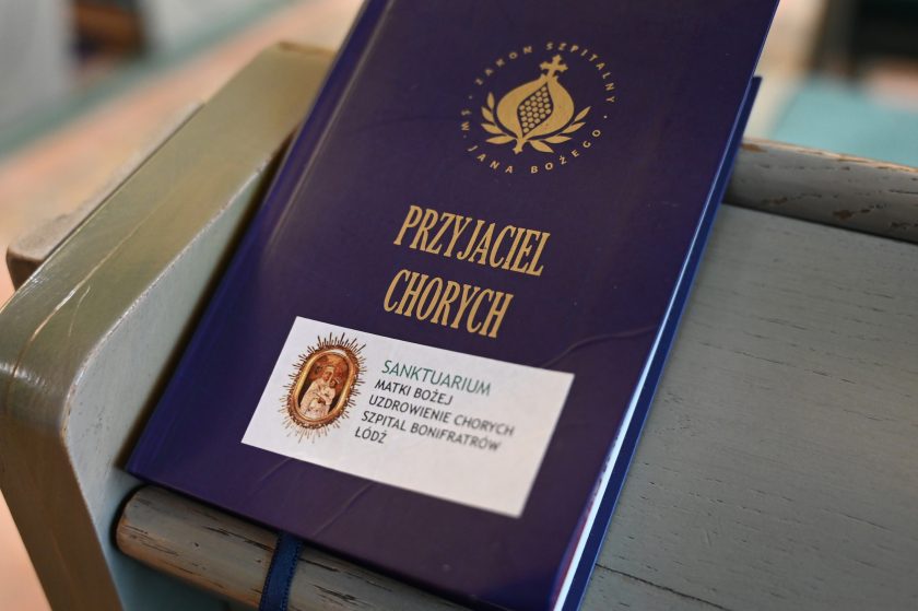 Zbliżenie na modlitewnik zatytułowany „Przyjaciel Chorych” z herbem Zakonu Bonifratrów. Na okładce naklejka z napisem „Sanktuarium Matki Bożej Uzdrowienie Chorych – Szpital Bonifratrów Łódź”