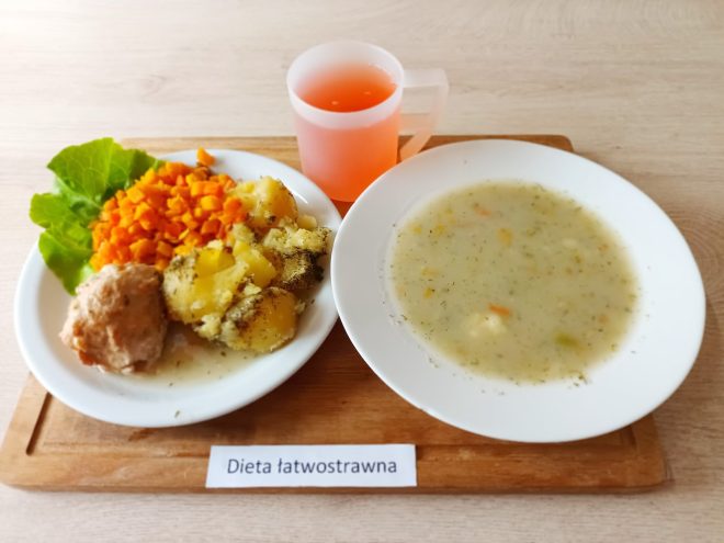 Śniadanie przygotowane zgodnie z zasadami diety łatwostrawnej: kilka kromek jasnego pieczywa, kostka masła, plasterki chudej wędliny drobiowej podane z liśćmi sałaty, miseczka kaszy manny na mleku oraz kubek czarnej herbaty. Tego typu posiłek dostarcza energii w lekkiej formie, przyjaznej dla przewodu pokarmowego