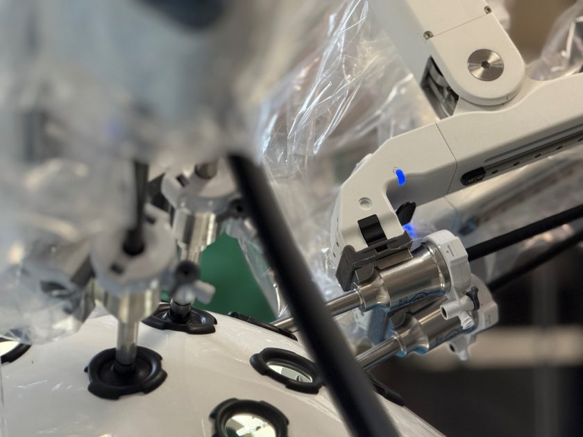 Zbliżenie na ramiona robota chirurgicznego w trakcie ćwiczeń – instrumenty wprowadzone są do specjalnej kopuły treningowej z licznymi otworami