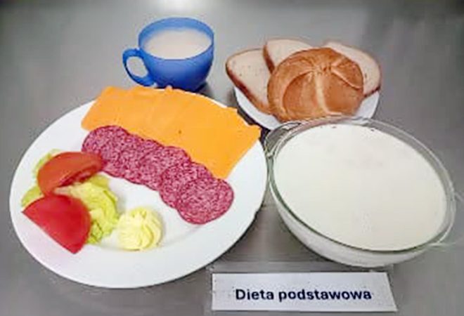 Śniadanie: pieczywo jasne i bułka, plasterki żółtego sera i salami, pomidor i sałata z masłem, do tego kubek kawy z mlekiem oraz miseczka kaszki mlecznej