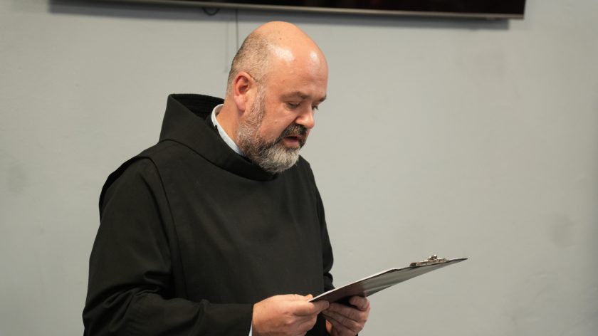 Zakonnik w czarnej habicie odczytuje tekst z kartki podczas części oficjalnej wydarzenia w Bonifraterskim Centrum Medycznym