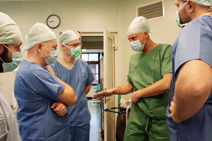 Zespół lekarzy prowadzi rozmowę tuż przed rozpoczęciem zabiegu. Uczestnicy wymieniają informacje i ustalenia dotyczące planowanego leczenia