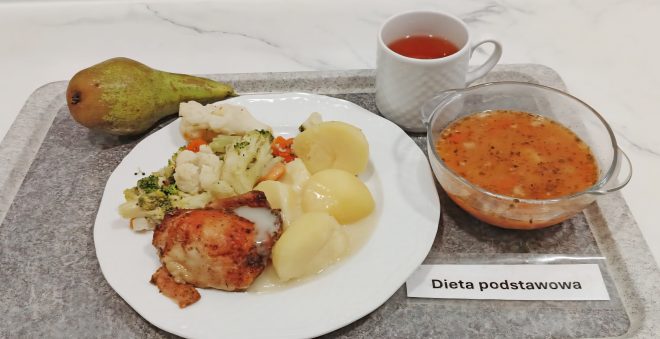 „Obiad w diecie podstawowej – porcja zupy jarzynowej, gotowane ziemniaki, udko z kurczaka w sosie i warzywa gotowane na parze. Do posiłku podano herbatę i gruszkę.