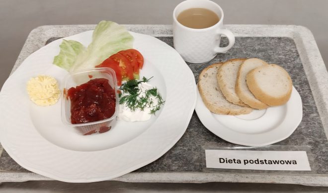 Śniadanie w diecie podstawowej: pieczywo pszenne, masło, twarożek ze śmietaną i koperkiem, pomidor i liść sałaty, a także konfitura owocowa. Do posiłku podano kawę z mlekiem
