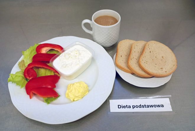 „Śniadanie w diecie podstawowej – pieczywo pszenne z twarożkiem, sałatą i świeżą papryką. Do posiłku podano odrobinę masła i kawę z mlekiem.