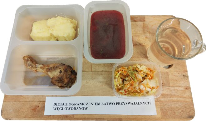 Obiad dietetyczny: pieczone udo z kurczaka, porcja puree ziemniaczanego, miska barszczu oraz surówka z kapusty i marchwi. Obok znajduje się kubek z wodą i etykieta ‘Dieta z ograniczeniem łatwo przyswajalnych węglowodanów.
