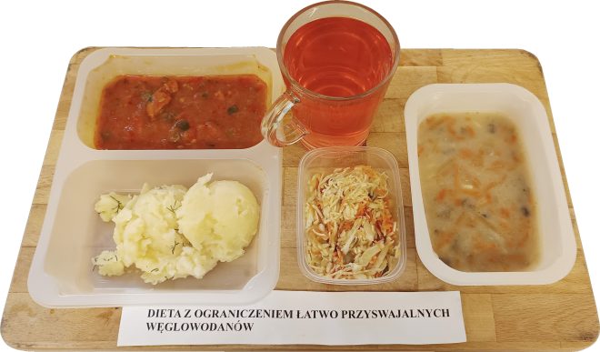 Zestaw obiadowy diety z ograniczeniem łatwo przyswajalnych węglowodanów: zupa, drugie danie z puree ziemniaczanym, surówka oraz napój, podane w pojemnikach