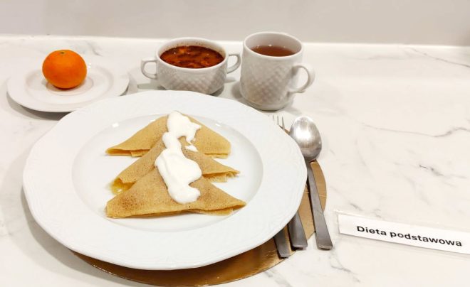 Posiłek w diecie podstawowej: trzy naleśniki polane jogurtem lub śmietaną, podane z herbatą, zupą oraz mandarynką
