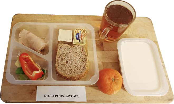 Śniadanie w diecie podstawowej: pieczywo, wędlina drobiowa, masło, warzywa, nabiał, owoc oraz herbata, podane w pojemnikach
