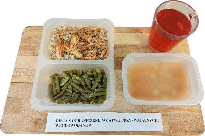 Porcja obiadowa w diecie z ograniczeniem łatwo przyswajalnych węglowodanów: kasza z szarpanym mięsem drobiowym, gotowana fasolka szparagowa, zupa jarzynowa w osobnym pojemniku oraz herbata owocowa
