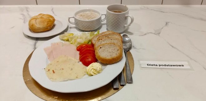 Śniadanie w diecie podstawowej: pieczywo pszenne, wędlina drobiowa, ser żółty, masło, pomidor i sałata, podane z kawą zbożową i zupą mleczną