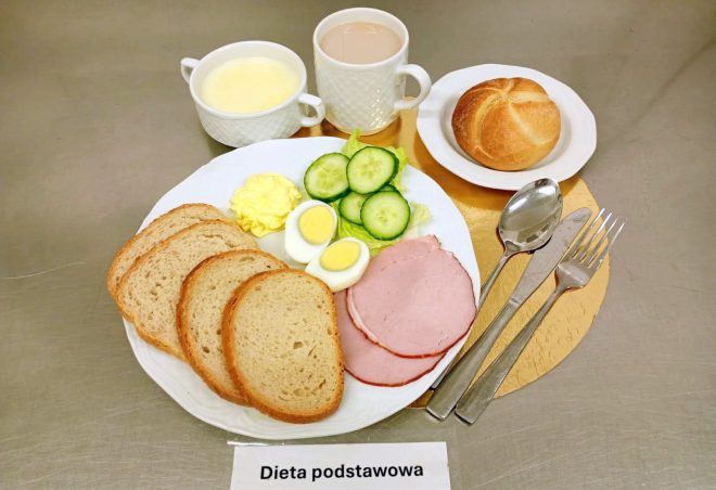 Śniadanie w diecie podstawowej: pieczywo pszenne, wędlina, jajko na twardo, ogórek świeży, masło oraz kawa zbożowa i zupa mleczna