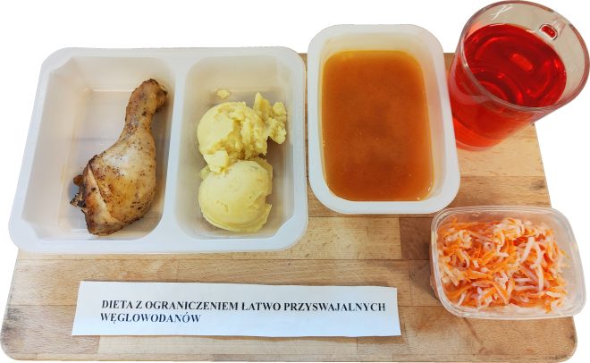 Zestaw obiadowy w diecie z ograniczeniem łatwo przyswajalnych węglowodanów: pieczona pałka z kurczaka, porcja puree ziemniaczanego, zupa pomidorowa, surówka z marchewki i napój owocowy
