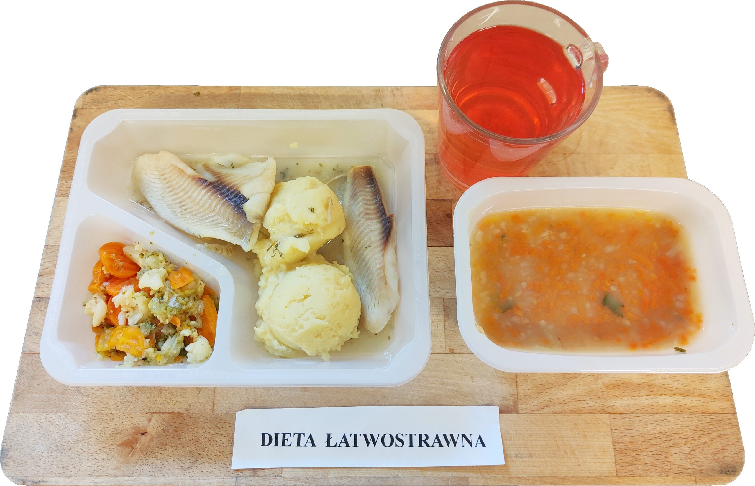 Obiad diety łatwostrawnej podany na tacy: gotowany filet rybny, puree ziemniaczane i gotowane warzywa (marchew, kalafior, brokuł). W osobnym pojemniku lekka zupa jarzynowa, a obok kubek czerwonej herbaty