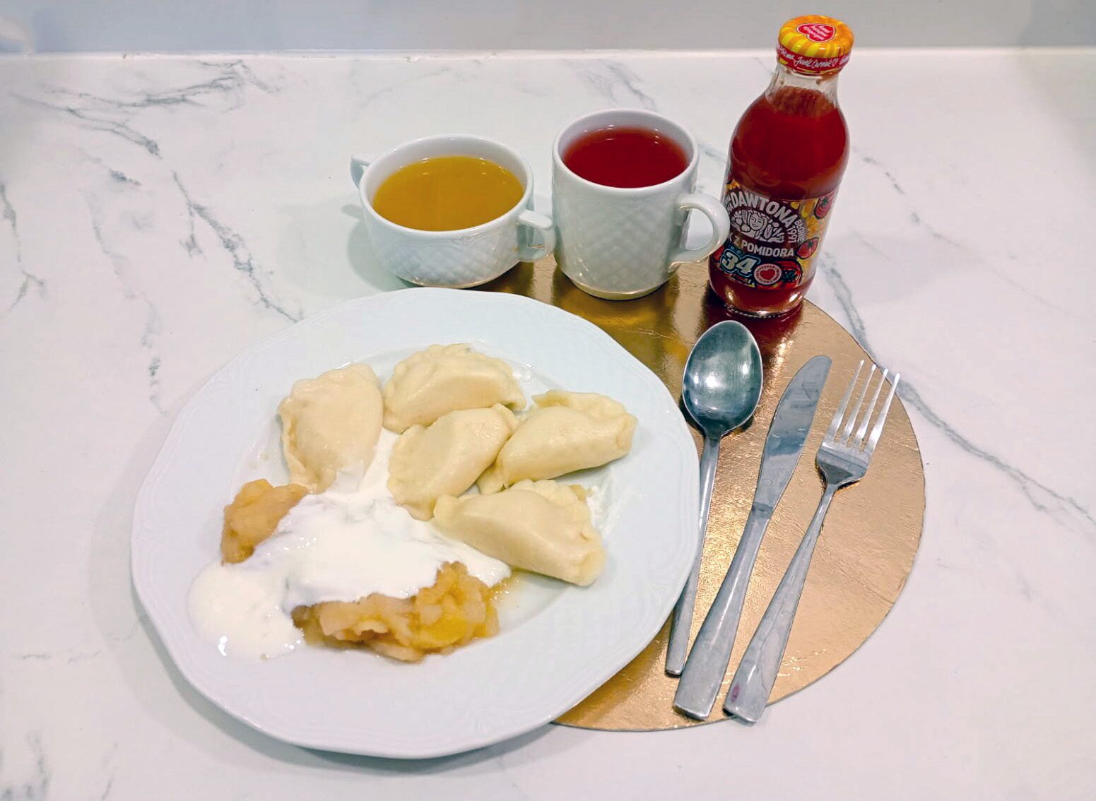 Obiad w diecie podstawowej: pierogi z nadzieniem podane z sosem śmietanowym oraz musem jabłkowym. Do posiłku herbata, kompot oraz butelka soku pomidorowego