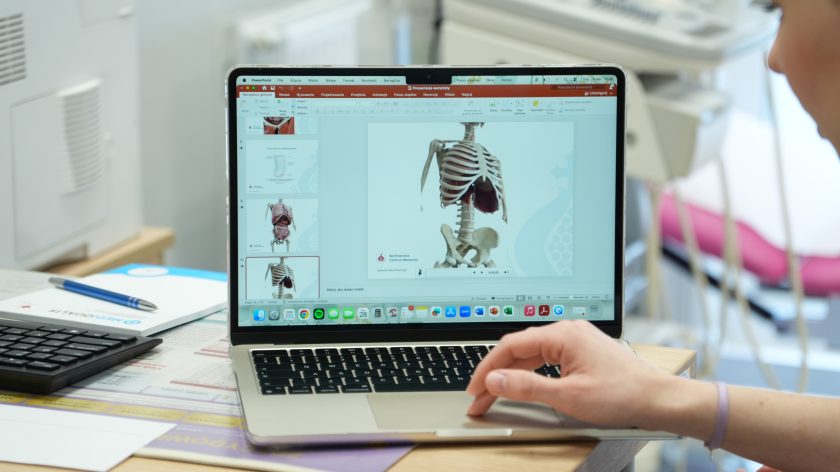 Zbliżenie na ekran laptopa z prezentacją medyczną przedstawiającą anatomię klatki piersiowej i narządów wewnętrznych