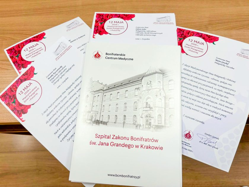 Publikacja poświęcona Szpitalowi Zakonu Bonifratrów św. Jana Grandego w Krakowie została ułożona centralnie na stole, wokół niej znajdują się okolicznościowe dyplomy dla pielęgniarek przygotowane z okazji Międzynarodowego Dnia Pielęgniarki i Położnej. Na okładce widoczny jest szkic zabytkowego budynku szpitala oraz logo Bonifraterskiego Centrum Medycznego