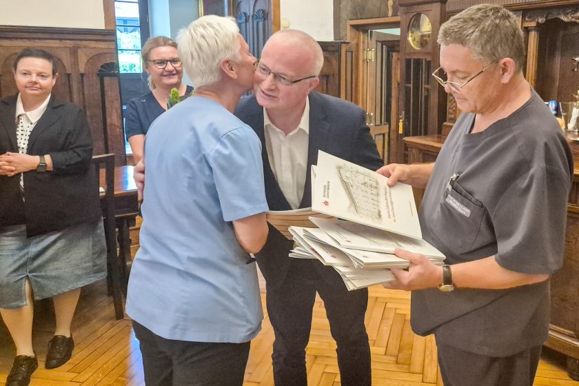 Mężczyzna składa gratulacje pracownicy szpitala podczas uroczystego spotkania personelu medycznego