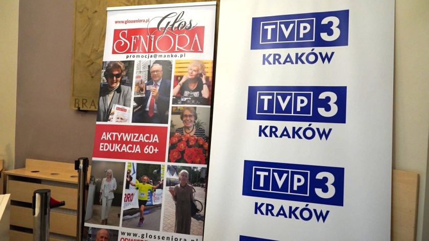 Roll-upy Głosu Seniora i TVP3 Kraków ustawione w holu budynku podczas wydarzenia skierowanego do seniorów