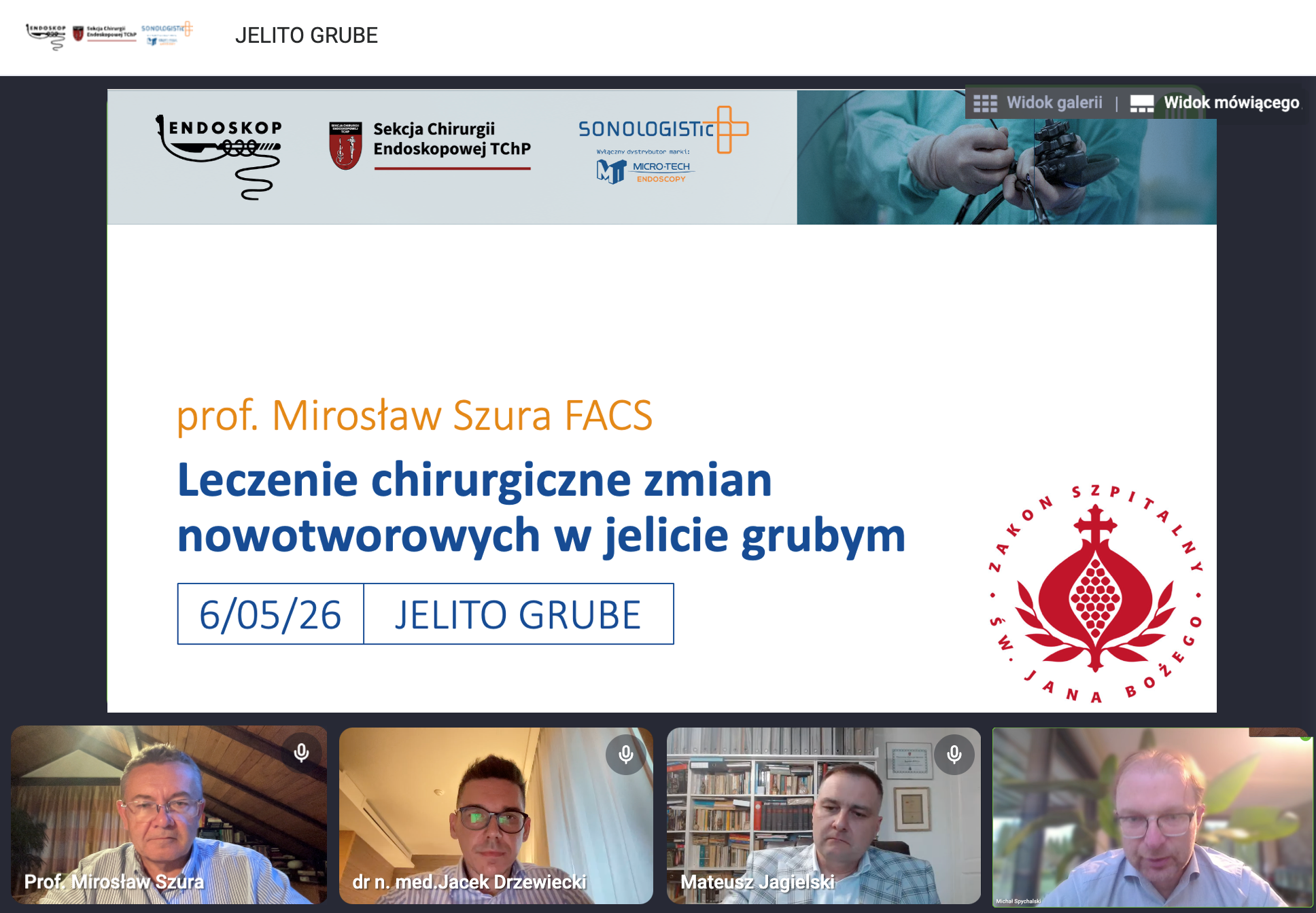 Zrzut ekranu z internetowego webinaru medycznego poświęconego chirurgicznemu leczeniu zmian nowotworowych w jelicie grubym. W centralnej części widoczny jest slajd prezentacji z białym tłem i granatowym nagłówkiem „JELITO GRUBE”. Na slajdzie znajdują się logotypy Endoskop 2026, Sekcji Chirurgii Endoskopowej TChP oraz firmy Sonologistic. Po prawej stronie baneru widoczne jest zdjęcie lekarza wykonującego badanie endoskopowe. Główny tytuł prezentacji zapisany dużymi niebieskimi literami brzmi: „Leczenie chirurgiczne zmian nowotworowych w jelicie grubym”. Nad nim umieszczono nazwisko prelegenta: „prof. Mirosław Szura FACS”. W dolnej części slajdu znajduje się data „6/05/26” oraz napis „JELITO GRUBE”. Po prawej stronie widoczne jest czerwone logo Szpitala św. Jana Bożego. U dołu ekranu widoczne są cztery okna uczestników spotkania online. W pierwszym oknie znajduje się prof. Mirosław Szura siedzący w pomieszczeniu z drewnianym sufitem. W drugim oknie widoczny jest dr n. med. Jacek Drzewiecki w okularach, siedzący przy biurku. W trzecim oknie pokazano Mateusza Jagielskiego na tle regału z książkami. W czwartym oknie znajduje się kolejny uczestnik spotkania siedzący w jasnym pomieszczeniu z roślinami w tle. W prawym górnym rogu slajdu znajdują się przyciski „Widok galerii” oraz „Widok mówiącego”