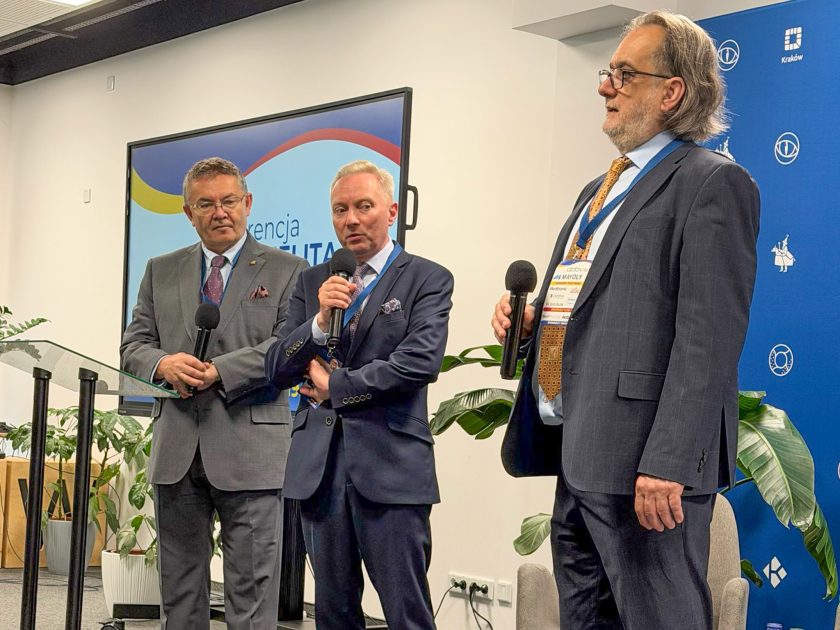 Panel dyskusyjny podczas konferencji edukacyjnej. Trzech ekspertów reprezentujących środowisko medyczne i samorządowe odpowiada na pytania uczestników oraz rozmawia o profilaktyce chorób jelita grubego