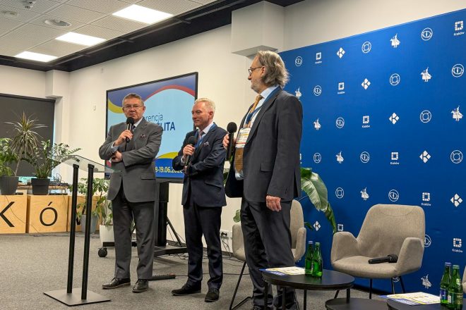 Uczestnicy panelu dyskusyjnego na scenie konferencyjnej. Eksperci prowadzą rozmowę na temat znaczenia badań przesiewowych i wczesnego wykrywania nowotworów jelita grubego wśród mieszkańców Krakowa