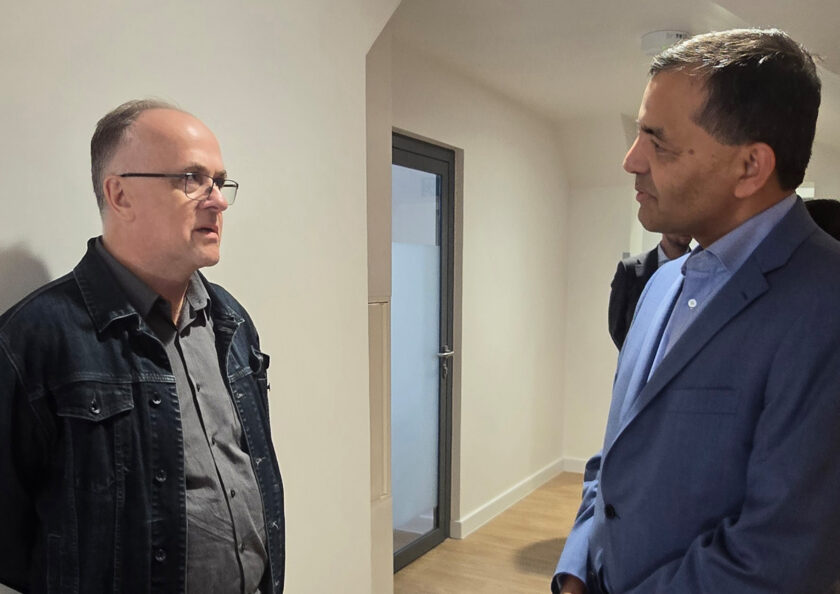 Dwóch mężczyzn rozmawiających podczas wizyty w pomieszczeniach placówki medycznej